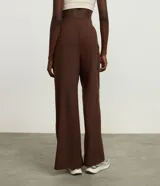 Pantalón deportivo de corte recto y holgado, color marrón, con cintura ancha elástica y pliegues frontales.