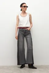 Jean wide leg bicolor en tonos de gris oscuro, con paneles laterales más oscuros y ruedo deshilachado.