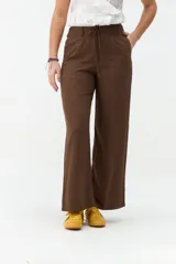 Pantalón marrón de corte ancho y relajado, con cintura elástica y cordón ajustable delantero.
