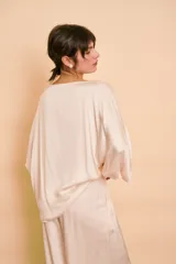 Blusa de satén color beige, con escote bote, corte holgado y mangas amplias tipo kimono.