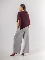 Poncho de corte holgado y diseño minimalista, confeccionado en tejido liviano de color beige, con cuello redondo y caída fluida.