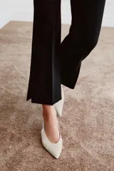 Zapato destalonado de piel en color blanco roto, con tacón kitten fino, puntera fina y tira elástica trasera.