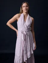 Vestido largo de gasa color lila con estampado floral, escote halter y lazo en la cintura.