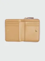 Billetera compacta con cierre de cremallera, color rosado pálido, con textura de cuero granulado. Presenta el texto "THE WALLET MARC JACOBS" estampado en el frente.