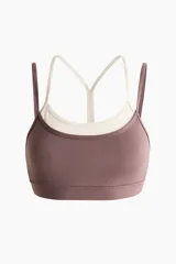 Top deportivo con SoftMove y DryMove, de sujeción media. Cuenta con escote redondo, copas con relleno extraíble y elástico cepillado en el bajo. Presenta un diseño de doble tiras finas en color contrastante que crea un efecto de superposición.