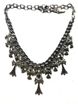 Collar de cadena plateada con eslabones gruesos y colgantes de cruces maltesas. La cadena principal tiene una sección de eslabones más finos y un cierre de mosquetón ajustable.