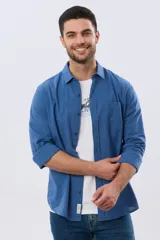 Camisa de lino de manga larga en color beige, con cuello camisero, cierre frontal de botones y un bolsillo ojal en el pecho.