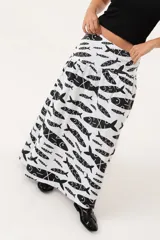 Maxi pollera blanca estampada con peces negros, de lino imperial, corte tipo caderín con frunces y tiro medio bajo.