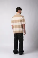 Remera tejida con cuello polo y rayas horizontales en tonos beige y crema, corte oversize y mangas cortas. Confeccionada en hilado de algodón.