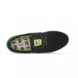 Championes de skate Emerica modelo Figgy G6 en colaboración con Shake Junt. Diseño de perfil bajo en color negro con detalles en verde vibrante en el cuello y la etiqueta de la lengüeta, montados sobre una suela blanca vulcanizada.