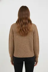 Polera de tejido acrílico azul, de corte holgado, con cuello tipo polera (mock neck) y mangas largas.