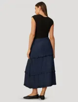 Pollera larga de lyocell en color azul, con diseño de paneles escalonados y volados en cada costura. Presenta cintura elástica fruncida para mayor comodidad.