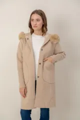 Tapado largo de textura combinada, con cuerpo de punto suave y mangas y bolsillos de tejido tipo corderito. Presenta cuello con capucha de piel sintética y cierre frontal con botones.