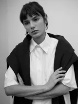 Camisa de corte oversize con cuello clásico, manga corta amplia y bolsillo frontal. Presenta un diseño con canesú y pliegue central en la espalda que brinda una caída fluida.