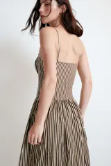 Vestido midi de popelín con estampado de rayas verticales. Presenta escote recto con detalle de pliegues, tirantes finos y falda con corte evasé. Incluye cierre lateral con cremallera oculta.
