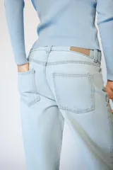 Jeans de tiro alto con cintura ancha, diseño de cinco bolsillos y pernera recta. Cierre frontal con cremallera y botón metálico.