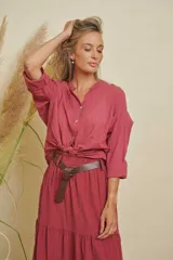 Camisa de lino color bordó, de manga larga con puños abotonados, cuello mao y cierre frontal con botones. La camisa está anudada en la parte delantera.