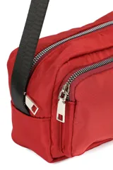 Bandolera color beige con correa ajustable negra. Cuenta con un compartimento principal con cierre y un bolsillo frontal con cierre.