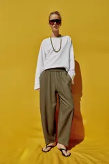 Pantalón de lino marrón oscuro, de corte barrel con pernera holgada que se estrecha hacia el tobillo, cintura elástica y bolsillos delanteros.
