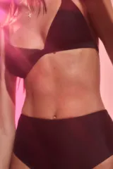 Conjunto de bikini negro confeccionado en lycra brillante. El corpiño es de estilo triángulo con breteles anchos fijos y pinzas para dar volumen. La bombacha es de tiro medio.