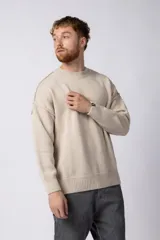 Sweater de punto grueso en color verde oliva, con diseño oversized, cuello redondo y mangas largas con puños acanalados.