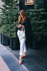 Bailarinas rojas con estampado tartán, anudadas al tobillo con cordones blancos y borlas decorativas.
