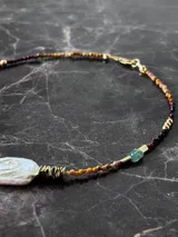 Gargantilla con cuentas de ojo de tigre, hematita, turmalina, separadores en oro laminado 14k (Goldfilled) y tres perlas centrales irregulares.