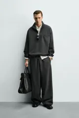 Pantalón de corte baggy fit confeccionado en tejido técnico, con cintura elástica ajustable mediante cordón y bajo con elásticos laterales para ajuste.