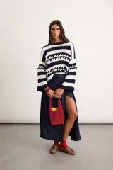 Bolso tipo cartera tejido en crochet de color fucsia, con diseño de red y asa de mano integrada.