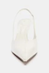 Zapato destalonado color blanco con efecto charol, tacón fino y tira trasera con elástico.