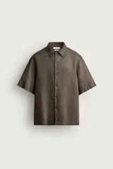Camisa de lino marrón oscuro con ajuste relajado, cuello bowling y mangas cortas. Cierre frontal con botonadura.