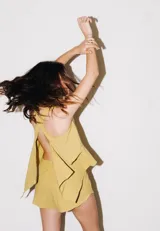 Conjunto color amarillo mostaza de blusa con espalda abierta y short con elástico en la cintura.