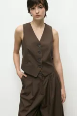 Chaleco sastrero marrón con cuello en V, cierre abotonado y bolsillos delanteros.