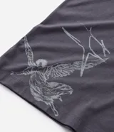 Remera de corte oversized color gris oscuro, con cuello redondo y manga corta. Presenta una estampa gráfica en la espalda que incluye un ángel, estrellas y el lettering 'No Mercy' junto a la frase 'Las calles no perdonan'.