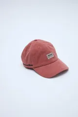 Gorra tipo dad hat de efecto lavado color rojo, con visera curva, grifa estampada en el frente y bordado lateral.