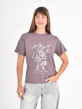 Remera color gris topo con estampa frontal en blanco que incluye gráficos de llaveros y la inscripción "Lucky Charm".
