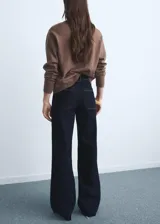 Pantalón de jean tiro alto con corte culotte y pernera ancha. Presenta cierre frontal con cremallera y botón, trabillas para cinturón, bolsillos traseros y bajo con acabado deshilachado.