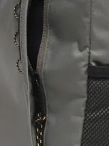 Mochila urbana Cat modelo Explorer, color gris, con compartimento principal, bolsillo frontal con cierre y bolsillos laterales de malla. Cuenta con panel trasero y correas acolchadas, y detalle de logo reflectante.