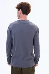 Buzo de manga larga con textura tipo waffle, cuello redondo y corte holgado.