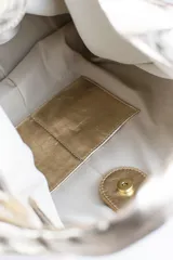 Cartera de cuero vacuno con pelo en diseño animal print similar a piel de ciervo, silueta triangular y asa integrada.