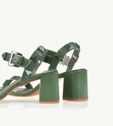 Sandalias de tacón color verde oliva, con tiras con apliques de tachas piramidales y hebilla metálica.