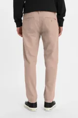 Pantalón tipo chino de corte estándar y pierna cónica, color rosa claro, con cierre de botón y cremallera, bolsillos laterales y traseros.