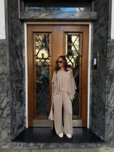 Pantalón de lanilla color beige, de corte recto y tiro alto, con diseño holgado y fluido.