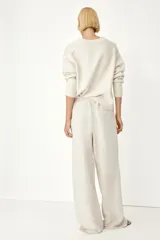 Pantalón recto color crema de tejido vaporoso en mezcla de lino. Modelo holgado con elástico y cordón de ajuste en la cintura, bolsillos laterales y traseros insertados.