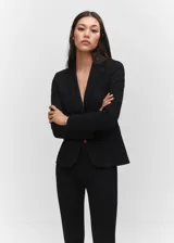 Blazer negro entallado de punto roma con solapas de muesca, hombros estructurados, abertura posterior y dos bolsillos de ribete delanteros.