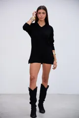 Sweater de punto acanalado color negro, con cuello en V y mangas largas. Presenta un diseño de corte holgado con aberturas laterales en el ruedo.