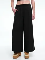 Pantalon de corte amplio y recto, color negro, con cintura elastizada y bolsillos laterales. Confeccionado en tejido fluido.