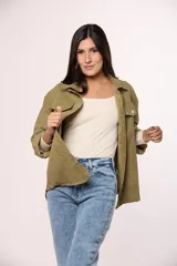 Camisa de pana fina color beige, con cuello clásico, cierre frontal de botones y dos bolsillos con solapa en el pecho.
