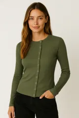 Remera de manga larga ajustada al cuerpo, color negro, con cuello redondo y cierre frontal de broches metálicos.