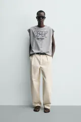 Camiseta sin mangas de corte relajado, color gris melange, con cuello redondo y estampa bordada en contraste en el frente.